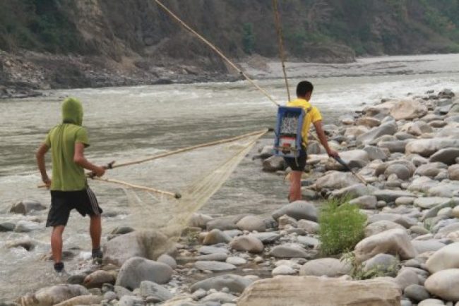 करेन्ट लगाएर माछा मार्दै दुई युवा